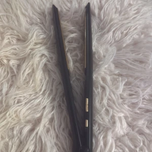 Plattång med justerbar temperatur - Svart plattång - fungerar bra trots slitage. Värmeplattorna har lite slitage och en liten brännmärkning, men det påverkar inte användningen. Perfekt för dig som vill ha en fungerande plattång till ett bra pris. 