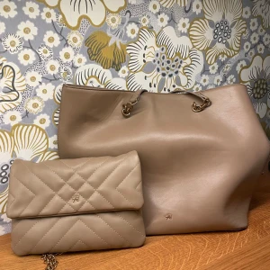 Beige väskset från Anna Field - Säljer ett snyggt set med två väskor från Anna Field i beige skinnimitation. Den större väskan har guldfärgade detaljer och rymligt innerfack med dragkedja. Den mindre väskan är quiltad med kedjerem och stilren design, perfekt för att bära det viktigaste. Väskan har gjort sitt men funktionen är topp !