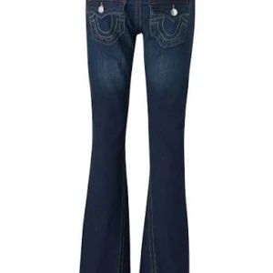 True-religion jeans storlek 24 - Snygga mörkblå true-religion jeans med bootcut-modell och markerade kontrastsömmar. Byxorna är midwaist och med klassiska fickor med dekorativa detaljer och knappar. Skriv om fler frågor eller bilder. Dock lite nötta längst ner på byxorna, men inget man tänker på💕💗
