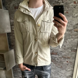 J.lindeberg Field Jacket - Mycket fint skick, en liten fläck, be om bild vid intresse😁. Storlek 48/S passar dig som är mellan 175-185cm. Nypris ca 4000kr. Benvit färg. Modellen är 185 cm, 79 kg. Passar bra nu till höst/vinter. Skriv för mer information!🤝 