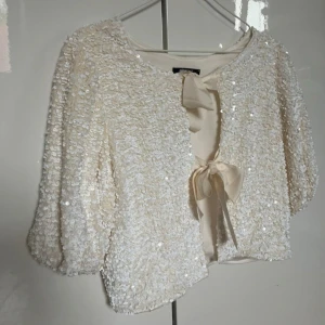 Fin vit blus🤍🥂 - Superfin topp/kofta från Gina Tricot i champagnefärgat tyg, täckt med paljetter. Endast använd en gång varsamt och där av inga skavanker🌸