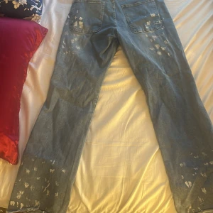Blå jeans med slitna detaljer - Säljer ett par blå jeans med coola slitningar och fransade benslut. Jeansen har raka ben och klassisk femficksdesign. Perfekta för dig som gillar en avslappnad och trendig look. Dem är i flared stil och är storlek M alltså 32-34 Köpte för 500 kr men använder inte dem längre säljare för 350 pris kan diskuteras 