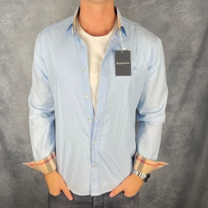 Burberry skjorta - Hej säljer nu min fina Burberry skjorta i storlek M. Den är i mycket bra skick och kommer vara otroligt snygg nu i höst. Nypris cirka 4000kr! Vi kommer att sälja liknande produkter så glöm inte följa profilen!🌊🍾