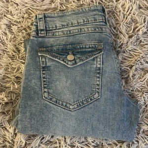 Ljusblå jeans från gina tricot - Snygga ljusblå jeans med tvättad look och en bakficka med lock och knapp. Klassisk femficksmodell med tydliga sömmar och bälteshällor. Perfekta för en avslappnad stil.