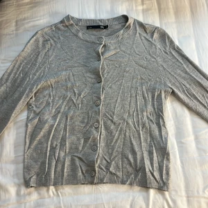 Grå kofta  - Grå kofta från lager 157. Klassisk rund halsringning, ribbade muddar och knäppning framtill. 💕