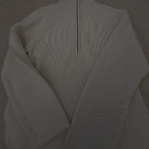 Beige ribbstickad half zip-tröja H&M - Ribbstickad beige tröja från H&M med half zip och hög krage. Långärmad och i mjukt, stickat material som ger en chill och stilren vibe. Perfekt för lager-på-lager och funkar året runt när du vill vara både bekväm och snygg.använd få gånger o har inga defekter 