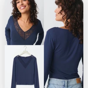 Mörkblå långärmad topp med spets - Snygg mörkblå långärmad topp med djup v-ringning och dekorativ spetsdetalj framtill. Toppens material känns mjukt och stretchigt, perfekt att styla med jeans eller kjol. Enkel men ändå elegant design som ger en cool vibe.