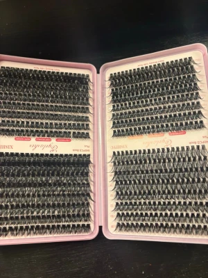 Svarta lösögonfransar i mixad längd - Säljer två kit med svarta lösögonfransar i olika längder. Fransarna kommer i en rosa ask och är organiserade i rader för enkel applicering. Perfekt för att skapa en fyllig och dramatisk franslook. Materialet är syntetiskt och ger en naturlig känsla. Det följer även med två oanvända pincetter. pris går alltid att diskuteras vid snabb affär. helt oanvänt allting.