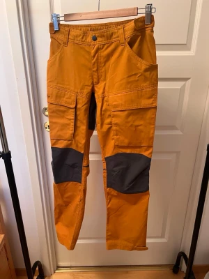 Lundhags Traverse 2 Juniorvandringsbyxa  - Gula Lundhags Traverse 2 juniorvandringsbyxor. Bekväm och stilren vandringsbyxa i vind- och vattenavvisande LPC-material. Använda endast fåtal gånger. Nypris: 645kr. 