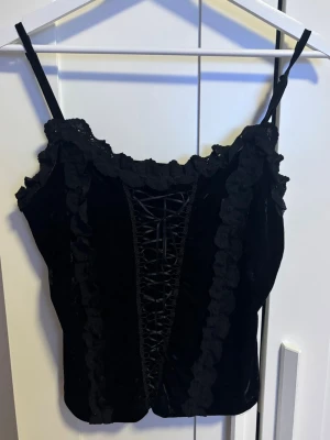 Svart linne - Svart linne med korsett-likande framsida som går att justera! Storlek står inte men skulle säga M 🩷materialet är typ velvet 