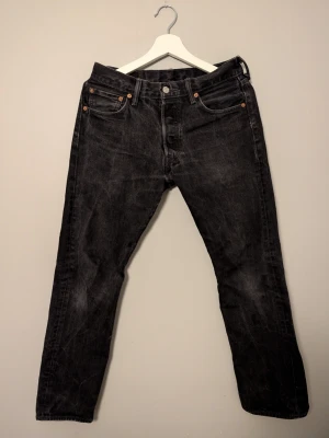 Svarta Levi's 501 jeans - Säljer svarta Levi's 501 jeans i storlek W30 L30. Jeansen är i bra skick utan några defekter. Priset är inte hugget i sten och det är bara att höra av sig vid frågor och funderingar!