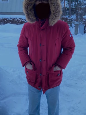 Parkajacka Tommy Hilfiger - En parkajacka från Tommy Hilfiger, användes för flera år sedan ett litet tag men passar inte längre helt. Den är varm och lång för kall vintrar. Den enda defekten som jag sett är ett litet hål i innerfickan som lätt går att sy igen.