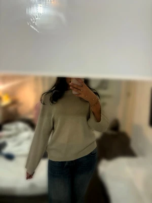 Beige stickad tröja - Selling a simple and stylish beige knitted sweater with a round neckline and long sleeves. Easy to match with jeans or a skirt for a relaxed and clean look. The sweater has a loose fit and feels soft and comfortable.