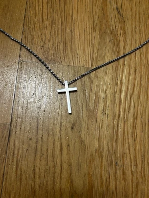 Silverfärgat halsband med kors - Premium kvalitet halsband med ett kors och kedja (silverfärgad) stainless steel är materialet som både kedjan och korset är gjort av. Tåligt och snyggt med mycket detalj på kedjan. Vem kan fråga för mer?