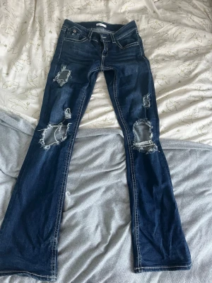 Slitna bootcut jeans  - Ett par snygga lågmidjade bootcut jeans med snygga slitningar och hål.