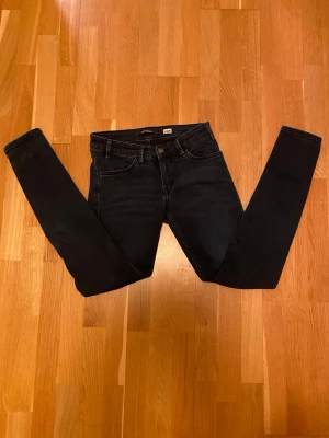 Mörkblå skinny jeans Saint Tropez 28/32 - Säljer ett par mörkblå skinny jeans från Saint Tropez i storlek 28/32. Jeansen har klassisk femficksdesign, silverfärgade nitar bak och knapp med logga. Snygg passform med smala ben och normal midja. Perfekta till vardagslooken!