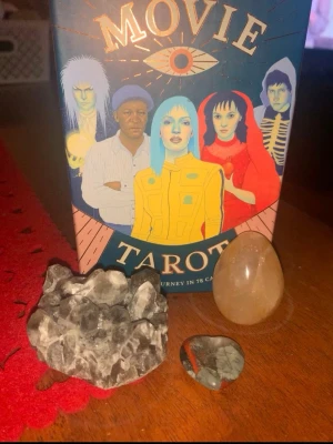 Tarotkort paket med kristaller! - Tarot kort paket med movie tarot, ett stort rökkvarts kluster,en blodsten worrystone och ett golden healer  ägg!   Tarot korten är i jätte fint skick men lådan är lite paj (se bild) men korten är hur fina som helst med film karaktärer som willy wonka,Ellen ripley osv. Allt är värt ca 360kr mitt pris för allt är 150kr med rabatt för korten! Vill du ha ett bra pris så kolla in detta 🙂
