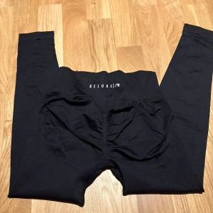 Relode träningstights - Säljer ett par svarta tränings tights från relode. De är helt oanvända, med lappen kvar och påsen till dem. Dem heter aura seamless scrunch tights petite. 