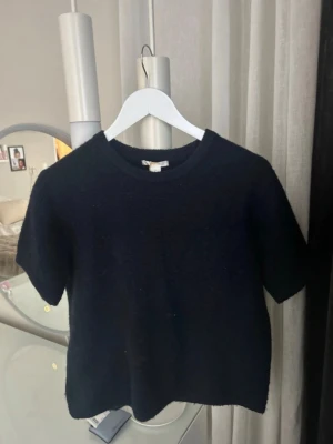 Navy Blue Knitted Short-Sleeve Sweater - Navy blue knitted short-sleeve sweater. It has been worn, but is still in great condition. Slightly pilled, but nothing noticeable and it still looks very nice. The price tag is still attached. Super comfortable and easy to style – looks great with many different pairs of jeans. Size 170, but fits like an XS/S as well.