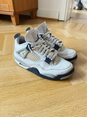 Nike Air Jordan 4 midnight navy - Säljer ett par Nike Air Jordan 4 Retro i vitt och marinblått. Skorna har klassisk meshpanel, detaljer i blått och grått med stänk, samt den ikoniska Jumpman-loggan på plösen och hälen. Ovandelen är i skinn och de har snörning samt en tjock, bekväm sula. Kommer med original låda dessutom, Pris kan diskuteras vid snabb affär, i gott skick och sällan använda
