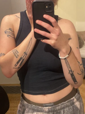 Svart ribbad linnetopp från Stay - Säljer en svart ribbad linnetopp från Stay i storlek S. Toppen är croppad med klassisk racerback-skärning och har en tight passform. Perfekt till sommaren och enkel att matcha med allt. Materialet är mjukt och stretchigt för en bekväm känsla.