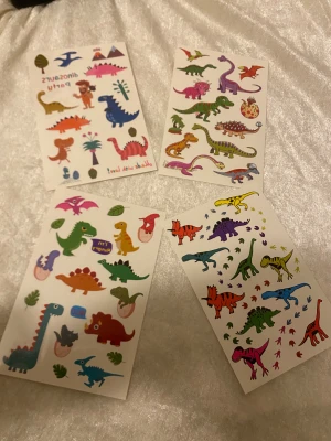 Färgglad dinosaurier Taturing  - Säljer en cool paket tatuering med färgglada dinosaurier i olika former och färger som blå, grön, röd, lila och gul. 