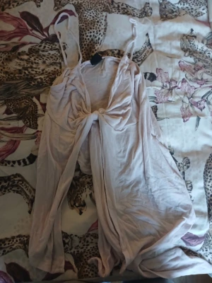 Ljusrosa linnetopp från Gina Tricot - Supersöt ljusrosa linnetopp från Gina Tricot i mjuk bomull. Toppen har smala axelband med knyt och en snygg knutdetalj framtill. Perfekt för varma dagar och enkel att styla med dina favoritjeans eller kjol. Obs tröjan är lite sönder som ni ser på sista bilden 