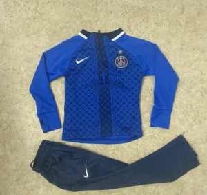 Mörkblå Nike träningsbyxor PSG - Säljer ett par mörkblå träningsbyxor från Nike med PSG-logga. Byxorna har en smal passform, elastisk midja med dragsko och vit Nike-logga på benet. Materialet är lätt polyester som andas och passar perfekt för fotbollsträning.