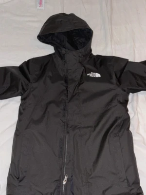The North Face vinterjacka – barn/ungdom strl L (146–151 cm) - Säljer en äkta The North Face vinterjacka i storlek L som motsvarar ca 146–151 cm. Jackan är i nyskick, endast använd 2–3 gånger och har inga tecken på användning. Jackan är stor i storlek. Jag skulle uppskatta att jackan är för åldrar mellan 11-14.   Den är köpt från Zalando och är 100% original. Varm och riktigt bra kvalitet, perfekt för kalla vinterdagar. Den är även vattentät.  Nypris: 1345 kr. Kommer från rök- och djurfritt hem.