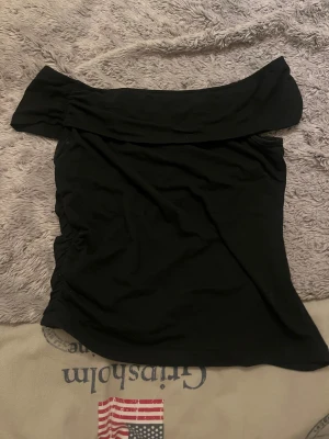 Svart offshoulder topp från SHEIN - Svart offshoulder topp från SHEIN i storlek S. Toppens design har en bred krage som ligger snyggt över axlarna och ger en cool, trendig vibe, en snygg söm i sidan på tröjan. Materialet är mjukt och stretchigt, perfekt för att sitta bekvämt. Tveka inte på att höra av er vid några frågor, tvättar allt innan jag skickar💗