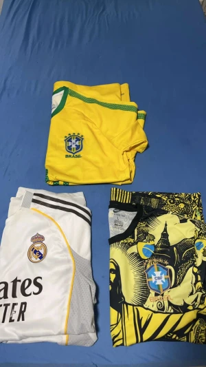 Ingen skor syns på bilden - Bilden visar inga skor, endast fotbollströjor från Brasilien och Real Madrid. Kan inte ge någon skobeskrivning eller taxonomier relaterade till skor.