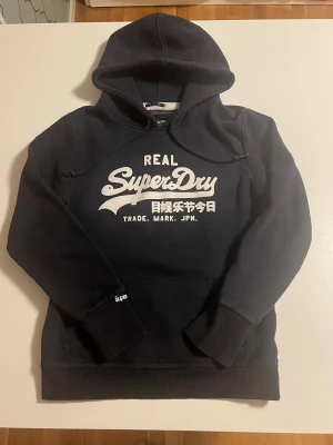 Superdry hoodie svart  - Superdry hoodie i svart färg. Helt perfekt skick inga fel. Storlek XS och passar 165-176 cm lång . Riktigt snygg perfekt inför vintern. Pris 348 kr högt tryck säljs snabbt kolla gärna mina andra annonser för mer och rabatt 😃