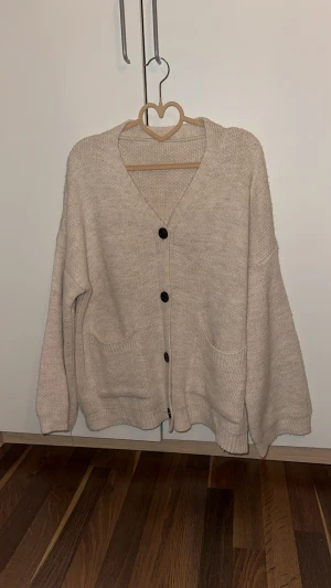 Beige stickad kofta med knappar - Köpt från frankrike använd kanske 1 gång inomhus, ganska lång, om du är 167+ borde den sitta ganska bra i längden, den är onesize och sitter lite större om du har xs-s men om du har S-M så är dett en tröja för dig.
