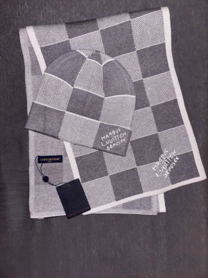 L V mössa med halsduk - Helt nytt L V-set i klassiskt rutmönster. Mössa och halsduk i matchande design, oanvänt med originaltaggar kvar. Perfekt som present eller för egen lyxig användning.