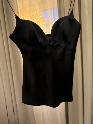 Zara svart satin topp - Supersnygg svart korsettinspirerad topp med tunna axelband i storlek XS. Knappt använd. Skickas nytvättad. 