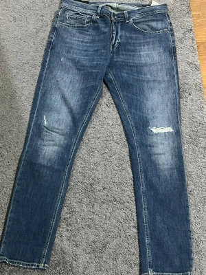 Dondup George skinny fit jeans blå 34 sitter som 33 - Säljer ett par blå skinny fit jeans från dondup i storlek 34. Jeansen har klassisk femficksdesign, slitna detaljer på benen och är tillverkade i jeansmaterial med snygg tvätt. Perfekt för dig som gillar smal passform och stilren look.
