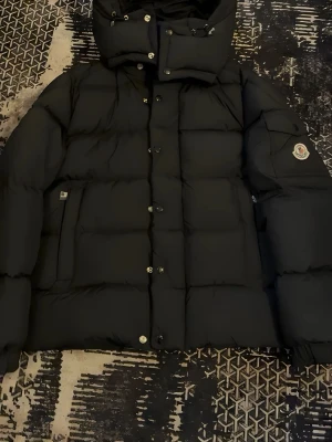 Svart Moncler vezere - Svart varm dunjacka med huva i fint skick. Klassisk och stilren modell som passar till allt. Kvitto kan ingå om ni ber om det, men då tillkommer 100 kr