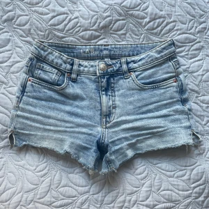 Ljusblå jeansshorts från LAB - Snygga ljusblå jeansshorts från LAB med fransiga kanter. Shortsen har en liten slits på sidorna. Storlek 146 och normala i storleken.