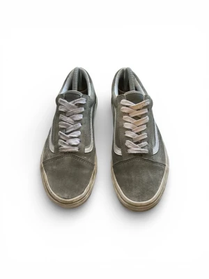 Grå Vans Old Skool sneakers - Säljer ett par grå Vans/gröna Old Skool sneakers med vit sula och vit sidostripes. Skorna har snörning och är tillverkade i mocka med klassisk låg profil och rund tå. Perfekt för dig som gillar streetwear och vill ha en stilren look.