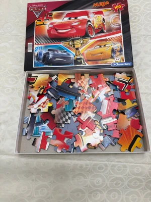 Cars 3 Mega 100 - Ett färgstarkt pussel med motiv från Cars 3, perfekt för dig som gillar snabba bilar och spännande tävlingar! Utmana dig själv eller vänner med 100 bitar och bygg ihop Lightning McQueen och hans vänner. Passar både unga och unga vuxna som älskar film och pussel.