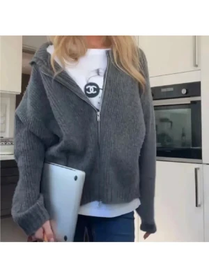 Grå ribbad kofta med dragkedja - Säljer en grå ribbstickad kofta med dragkedja framtill. Koftan har en loose passform och långa ärmar, perfekt att slänga på över en t-shirt. Materialet är stickat och ger en mysig känsla. Enkel och stilren design som funkar till jeans eller leggings.