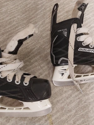 Skridskor Bauer Nexus 200 storlek 28 - Säljer ett par begagnade Bauer Nexus 200 skridskor i svart färg. Har funkat bra men nu har dottern vuxit ur dom. Storlek 28