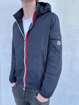 Moncler Windbreaker  - Säljer nu denna tvärfeta windbreaker från Moncler! Skick 9/10 - enda defekt är att lappen i nacken har lossnat. Nypris 8995kr, mitt pris endast 2299. Storlek 4, passar M/L (modellen är 186 cm). Hör av er vid funderingar!