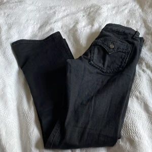 Svarta jeans från Gina Tricot - Säljer ett par svarta jeans från Gina Tricot med snyggt dekorerad bakficka och dragkedja fram. Jeansen har klassisk femficksdesign och är tillverkade i ett mjukt bomullsmaterial med lite stretch. Perfekta till en chill vardagslook.