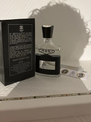 Creed Aventus 100ml parfym - Creed Aventus, ikonisk parfym i 100ml flaska. Lyxig känsla och stilren design, perfekt för dig som vill sticka ut. Originalförpackning och äkthetskort medföljer. Tillverkad av det klassiska parfymhuset Creed, grundat 1760. Ca 85ml kvar