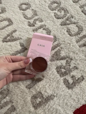 CAIA Soft Melt Blush Balm Butter Toast - CAIA Soft Melt Blush Balm i nyansen Butter Toast. Krämrouge i en varm brunrosa ton, perfekt för att ge kinderna en naturlig glow. Kommer i en söt rosa kartong och genomskinlig rund plastförpackning. Innehåller 3 g produkt.