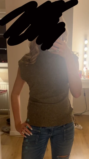 Grön ärmlös topp i stickad stil - Säljer en beige ärmlös topp med rund hals och rak passform. Toppen har en enkel och clean look, perfekt att matcha med jeans eller kjol. Materialet är stickat och känns mjukt mot huden. Perfekt för dig som gillar en stilren vibe.