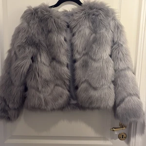 Grå pälsjacka  - Grå pälsjacka från hm. Går att stänga. Använd 1-2 gånger mycket bra skick! Storlek xs-s skulle jag säga 👍