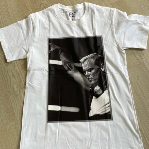 T-shirt med DJ-tryck från CE - Oanvänd, oöppnad förpackning! Cool t-shirt från CE med stort svartvitt tryck av en Avicii på framsidan. Finns i både vitt och svart. Klassisk rund hals och korta ärmar, perfekt för dig som gillar en avslappnad.