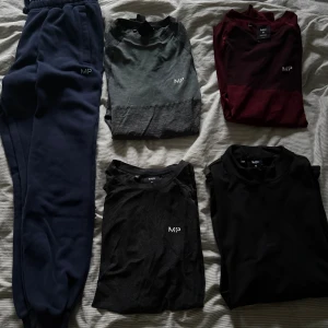 Svart långärmad tröja från MP - 1. Mörkblåa mjukisbyxor storlek S.         2. Mörkgrå långärmad compression shirt  storlek xs.    3. Röd långärmad compression shirt  storlek xs        4. Mörkgrå T-shirt storlek S.        5. Svart half zip storlek S